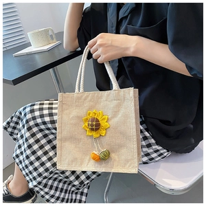 Detail of beige linen tote bag with sunflower decoration and rope handle
