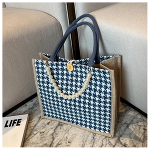 Detail of houndstooth tote bag with jute trim, rope handles and pearl chain accent
