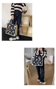 Detail of a large canvas tote bag featuring black and white cow print and beige piping trims