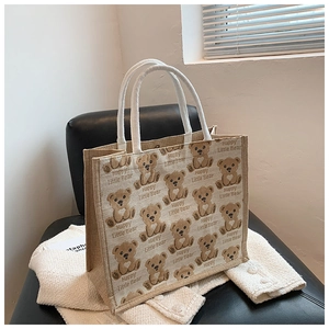 Detail of linen tote bag with cartoon bear print and white braided cotton rope handles