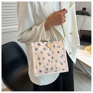 Dettaglio della mini borsa a fiori rosa con rete in pizzo bianco e manici in cotone