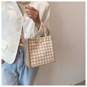 Detail of houndstooth linen handbag with a wooden button and rustic rope handle
