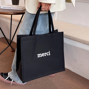 Minimalist black canvas tote bag with white merci print for casual daily commuting