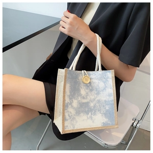 Dettaglio mini borsa in lino tie-dye blu con bottone in legno e manici in corda