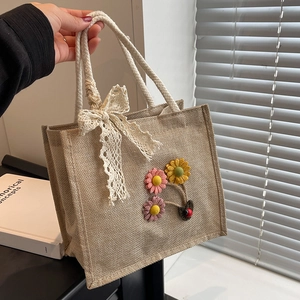 Linen tote bag with sunflower decor, lace bow, and sturdy rope handles in natural jute style