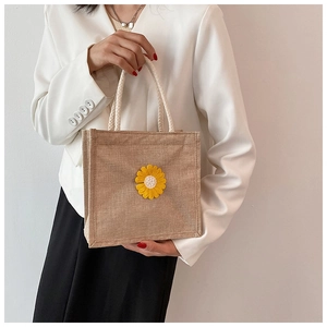 Close-up of burlap tote bag with sunflower applique and white braided rope handles