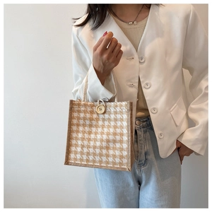 Close-up of linen tote bag with houndstooth pattern and woven rope handles