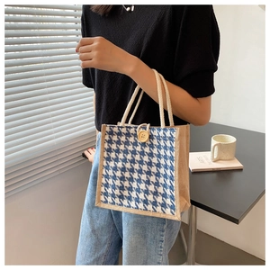 Detail of blue houndstooth woven linen tote bag featuring wooden button and rope handle