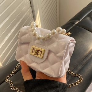 Mini white jelly crossbody bag with quilted pattern, pearl handle, and gold chain strap