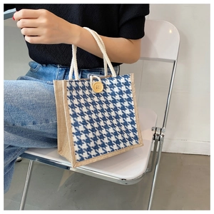 Close-up of linen tote bag featuring blue houndstooth fabric and woven rope handle