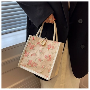 Dettaglio della borsa beige con ricamo floreale rosa e motivo a trapunta a rombi