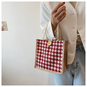 Close-up of red houndstooth linen tote with jute side panels and wooden button detail