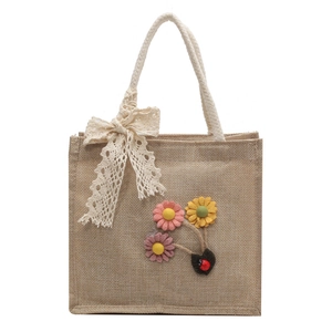 Linen handbag with lace bow and floral 3D details on a natural jute woven texture