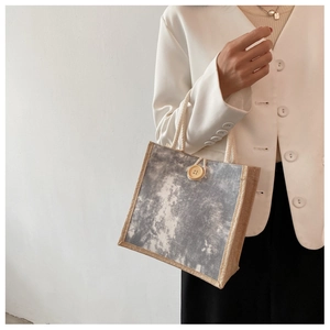 Dettaglio della borsa tote in lino con manico in corda e bottone in legno da donna