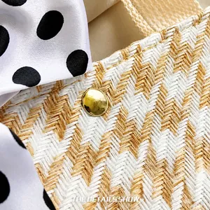 Close-up of straw woven texture with golden stud and black polka dot ribbon bow