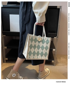 Detail of canvas tote bag with green diamond pattern, rope handles and wooden button