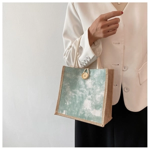 Dettaglio mini borsa tote in tela tie-dye verde con finiture in iuta e bottone in legno