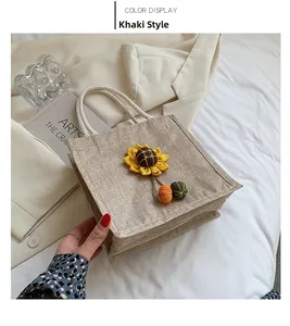Detail of khaki jute tote bag with sunflower motif and rope handles for summer style
