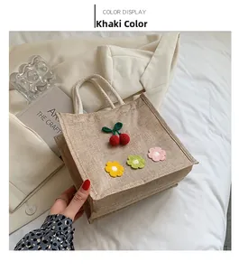 Detailed macro view of khaki jute tote bag with crochet cherry and floral accents