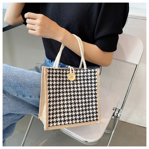 Close-up of houndstooth linen tote bag with wooden button and woven cotton handles