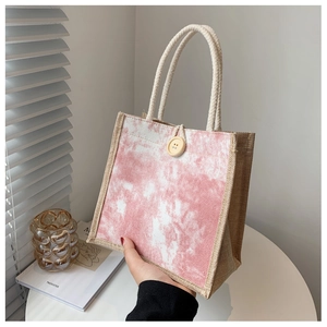 Dettaglio borsa in lino con stampa tie-dye rosa, bottone in legno e manico in cotone