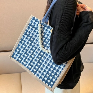 Blue houndstooth tote bag with pearl strap and denim handles for stylish commuting