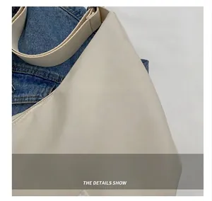 Détail d'un sac à bandoulière beige montrant la texture lisse du tissu de haute qualité