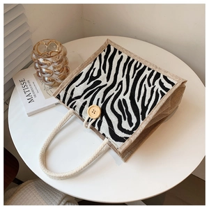 Detail of linen tote bag with zebra pattern panel and wooden button closure