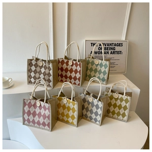 Detail view of colorful argyle canvas tote bags with wooden buttons and rope handles