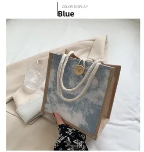 Dettaglio della borsa in lino blu tie-dye con manici in corda di cotone e bottone in legno