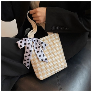 Close-up of woven chevron tote bag with magnetic clasp and polka dot scarf detail