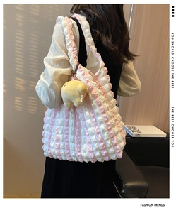 Detailed view of pink striped puff tote bag with a cute plush chick keychain accessory