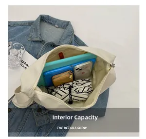 Détail de la capacité intérieure du sac bandoulière blanc avec tablette et accessoires