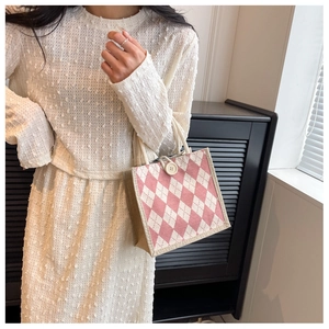 Detail of pink and white argyle canvas tote bag featuring large white button closure