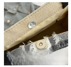 Gros plan du fermoir magnétique sur le sac fourre-tout en toile à motif à carreaux