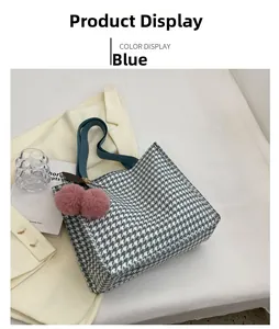 Detail of blue houndstooth canvas tote bag with teal strap and pink pompom charm