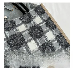 Détail de la texture à carreaux avec bords effilochés et bordure en bois tissé sur le sac