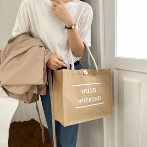 Detail of jute tote bag showing natural texture and Hello Weekend print with rope handle
