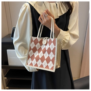 Close-up of red and white lattice canvas tote with woven rope handles and button detail