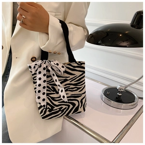 Detailed shot of zebra pattern canvas tote featuring a chic polka dot bow ribbon detail