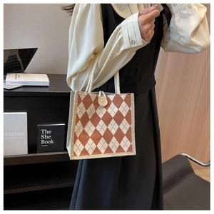Close-up of small argyle canvas tote bag with large button closure and rope handle