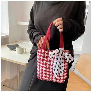 Detail of red houndstooth mini tote bag with polka dot bow and red handles