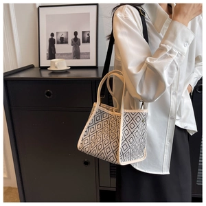 Detail of a geometric diamond pattern tote bag with a wide detachable black shoulder strap