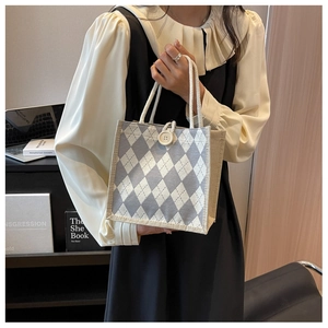 Detail of canvas tote bag with argyle pattern, cotton rope handle and button closure