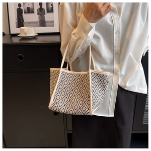 Detail of checkered tote bag with geometric pattern and faux leather cream handles