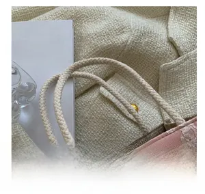 Sac à lunch rose avec grand bouton en bois et détails de poignées tissées élégantes
