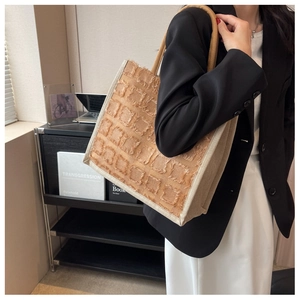 Détail d'un grand sac cabas en toile avec texture à franges marron et anses en corde