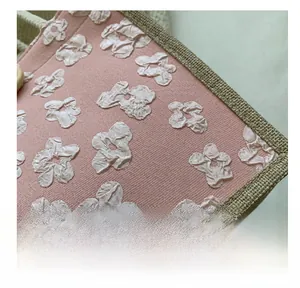 Gros plan sur le sac en lin rose avec broderies florales 3D et bordure naturelle
