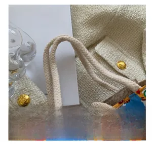Detail of cute linen tote bag with braided cotton rope handles and a large wooden button