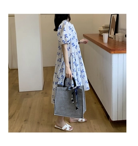 Detail of houndstooth canvas tote bag with a floral scarf tied to the top handle